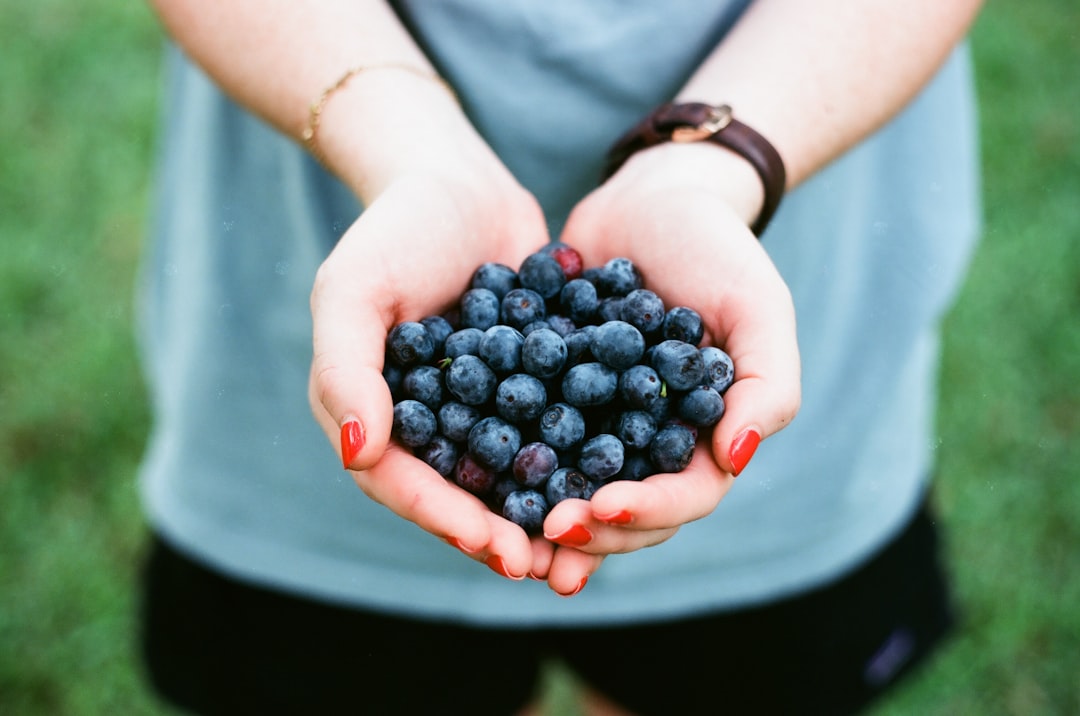 Photo by andrew welch person showing blue berries